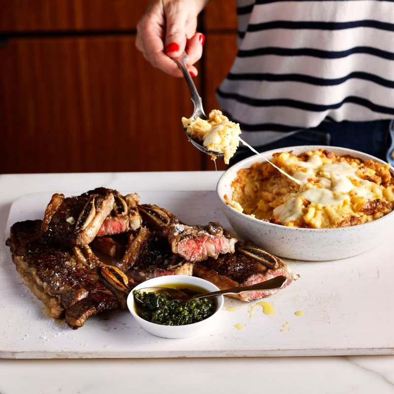 Person serving food from a dish onto a plate with a fork.