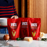 Three red Vics bags on a table with ingredients in the foreground